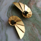 brincos nautilus party com banho de ouro e pirites, em fundo de marmore